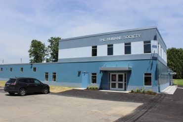 Outside view of humane society with building sign visible from parking lot.