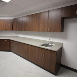 Clean prep area inside humane society featuring storage cabinets and utility sink.