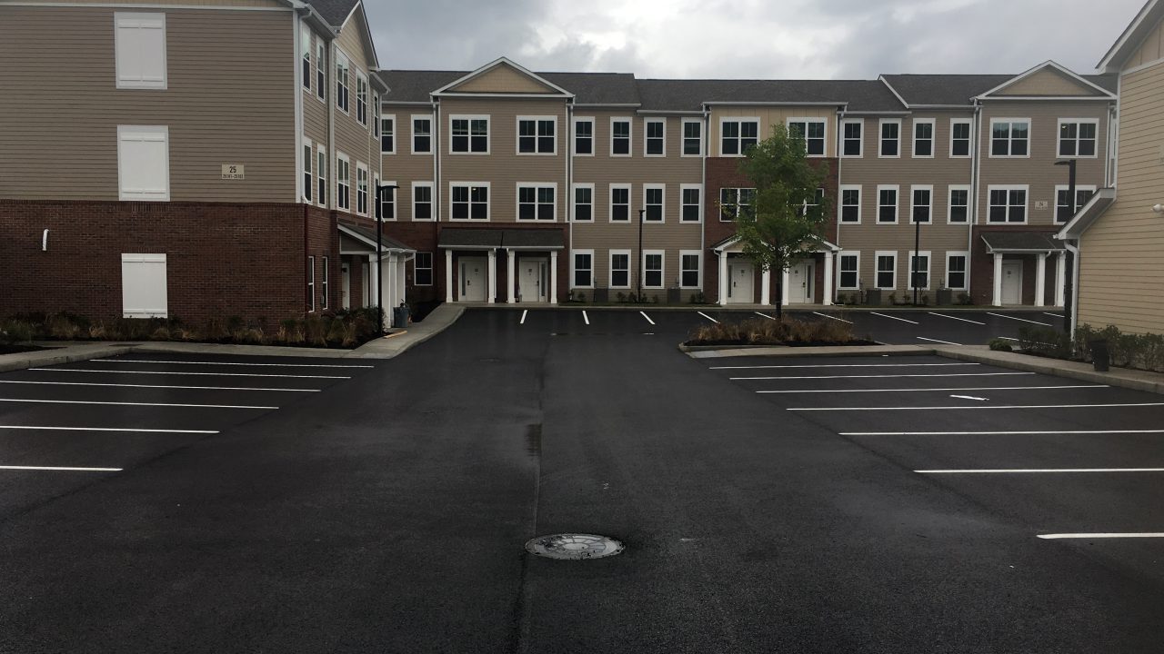 Apartment complex buildings surrounding central parking lot.