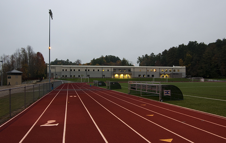 Exterior image of running track with Kerr-Pegula Athletic Field House in background at night.
