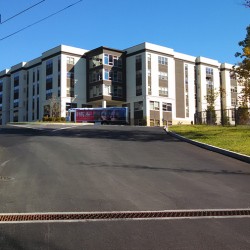 Image of lot access with drainage feature and building in the background.