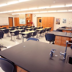 Interior image of science classroom featuring lab tables, desks, and chairs.