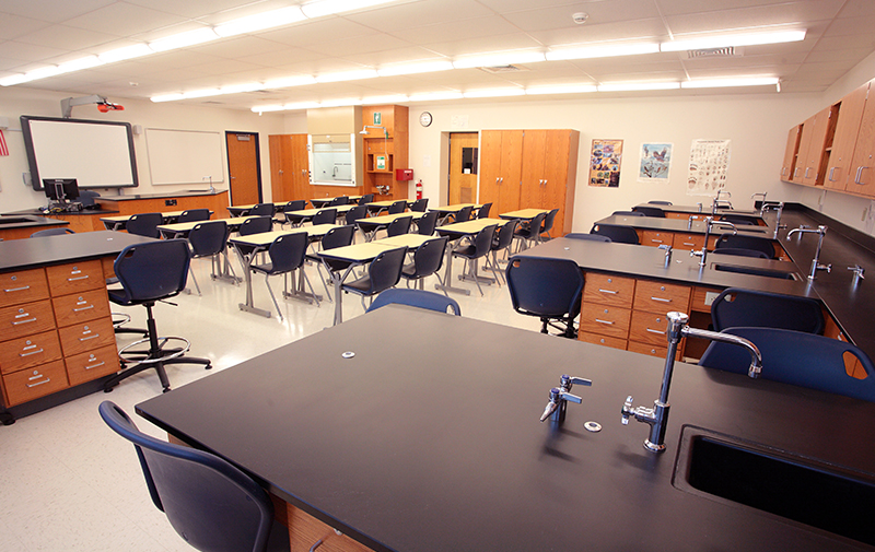 Interior image of science classroom featuring lab tables, desks, and chairs.