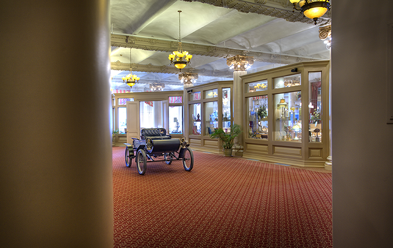 Interior image of historic building featuring old car in lobby.