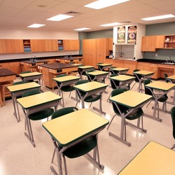 Interior image of science classroom featuring student desks and lab tables.