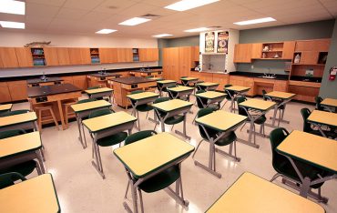 Interior image of science classroom featuring student desks and lab tables.