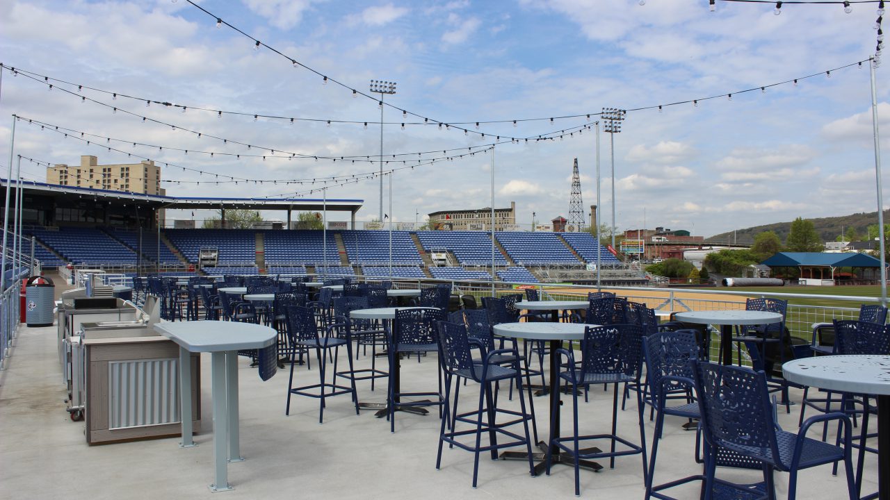 Picnic area at Mirabito Stadium, formerly NYSEG Stadium, featuring shaded tables, casual seating, and views of the field designed for fan gatherings and outdoor dining.