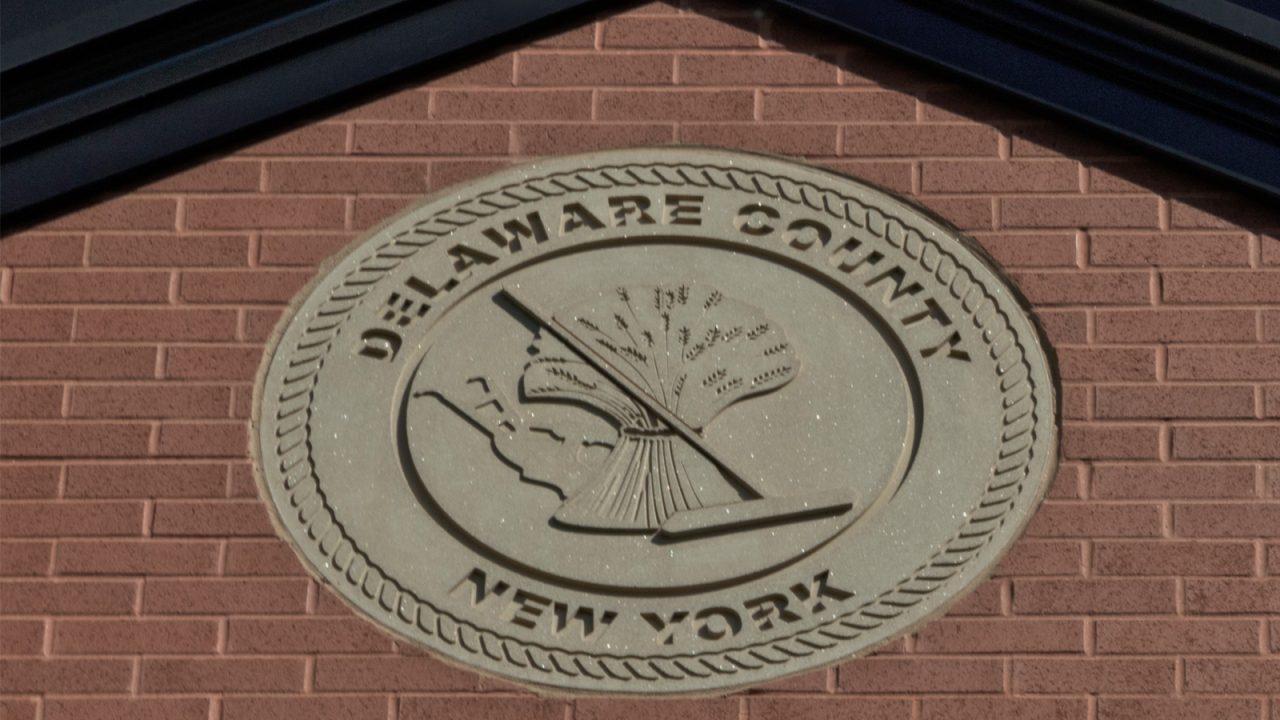 Close-up view of the Delaware County seal displayed on the building, showcasing its detailed design and official emblem.